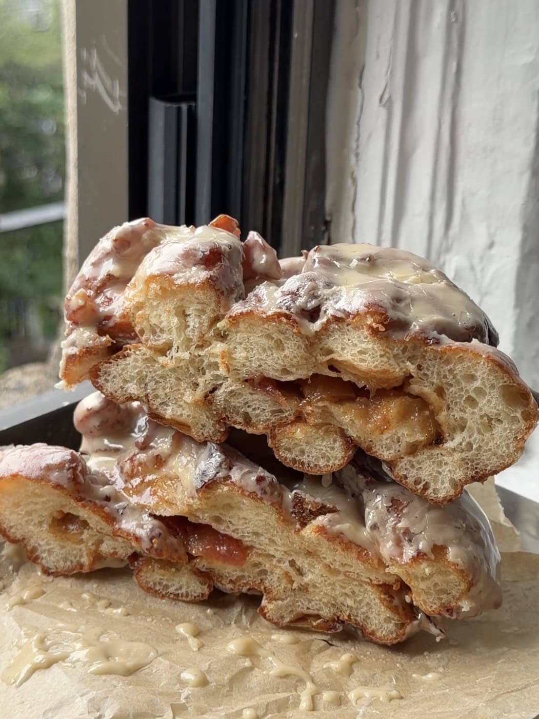 Side view of an Apple Fritter cut in half showing the apple compote filling.