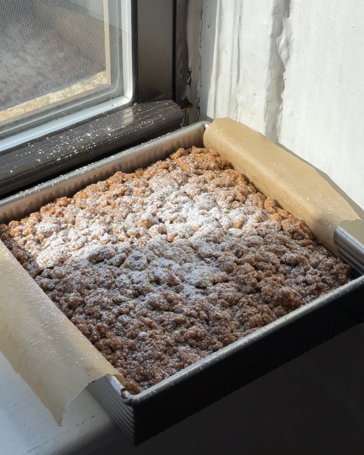 Overhead view of a Brown Sugar Pumpkin Coffee Cake dusted with powdered sugar.