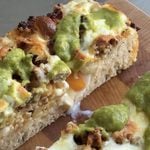 Side view of a slice of Breakfast Burrito Focaccia showing the runny egg yolk.