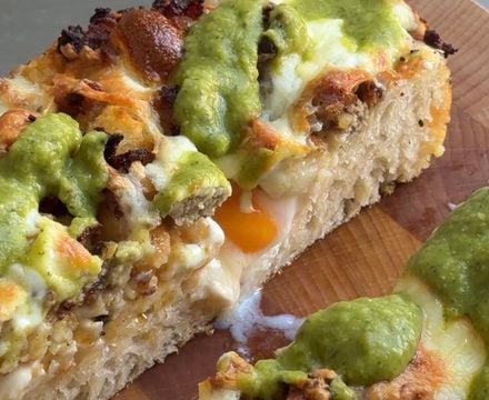 Side view of a slice of Breakfast Burrito Focaccia showing the runny egg yolk.
