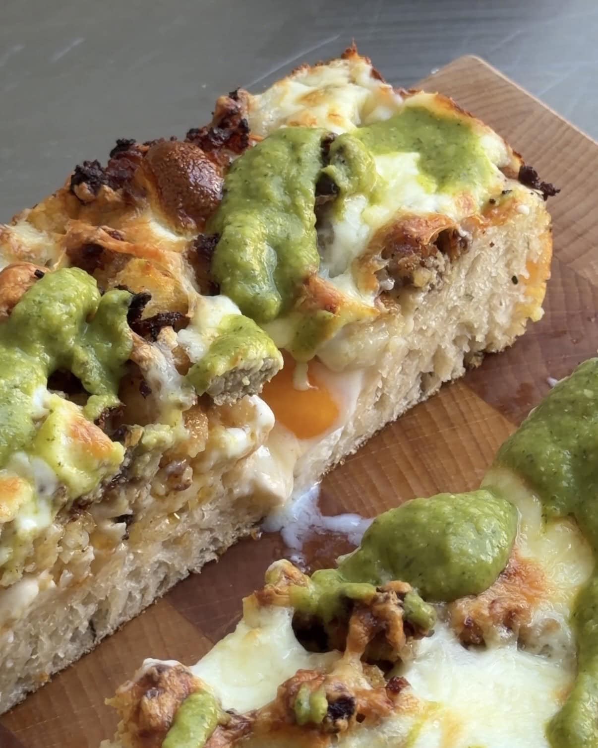 Side view of a slice of Breakfast Burrito Focaccia showing the runny egg yolk.