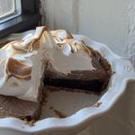 Side view of a Brownie S'mores pie in a white pie dish.